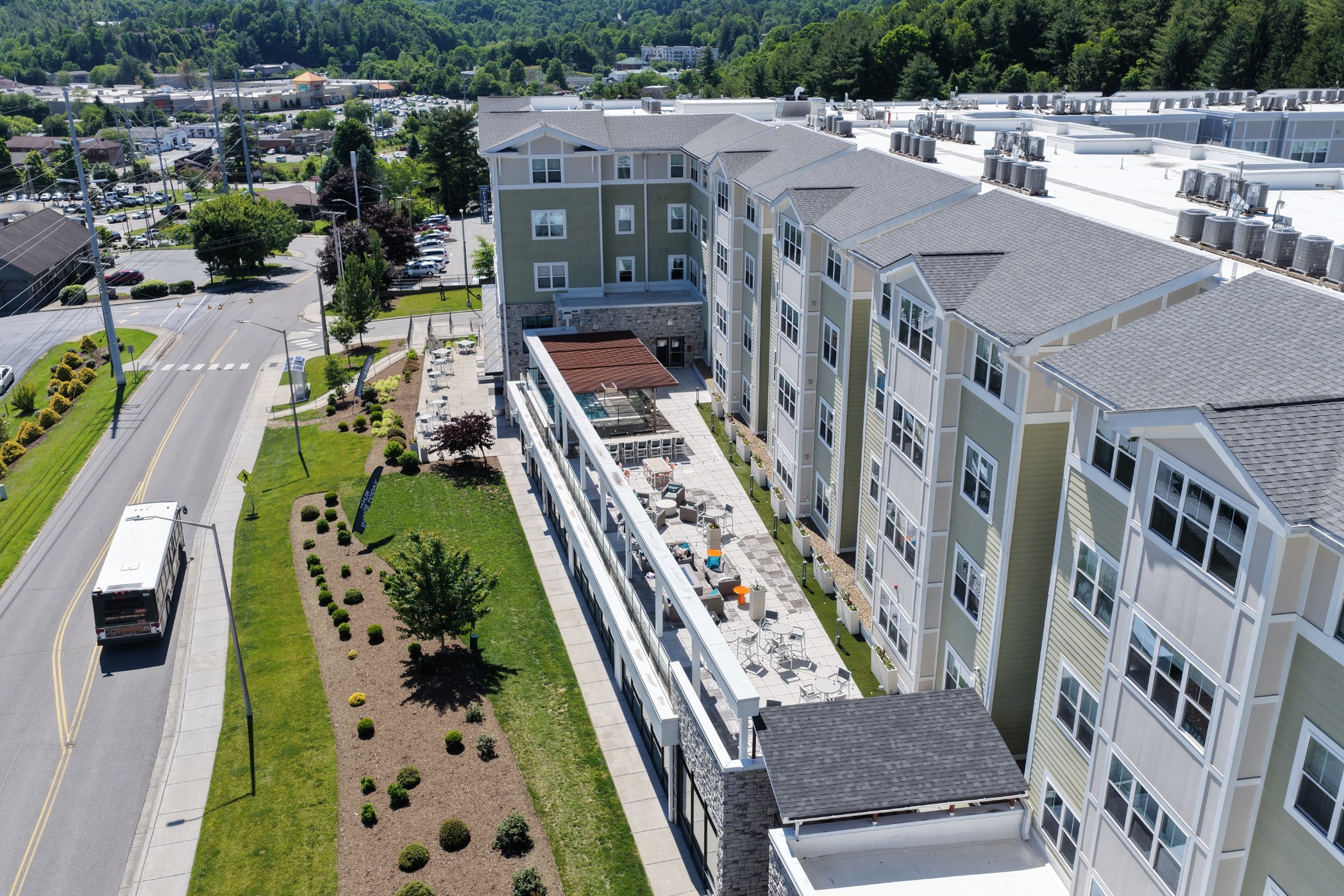 Aerial view of the outdoor amenity patio with App State campus transit passing by