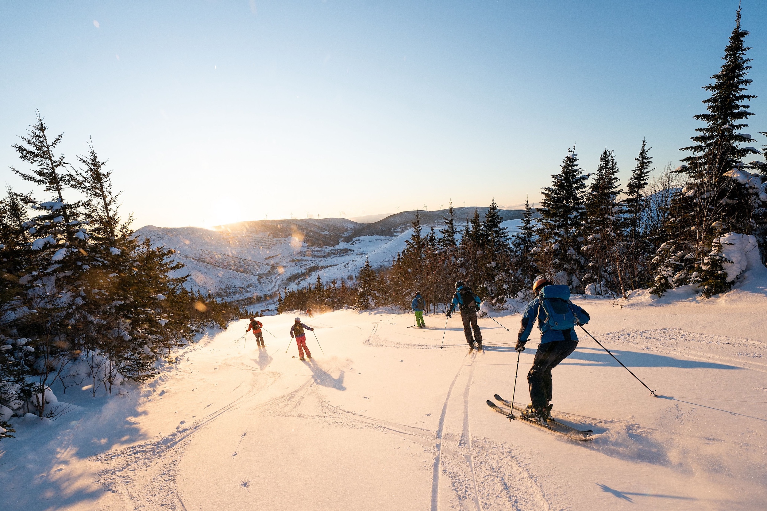backcountry skiers descending mountain slope
