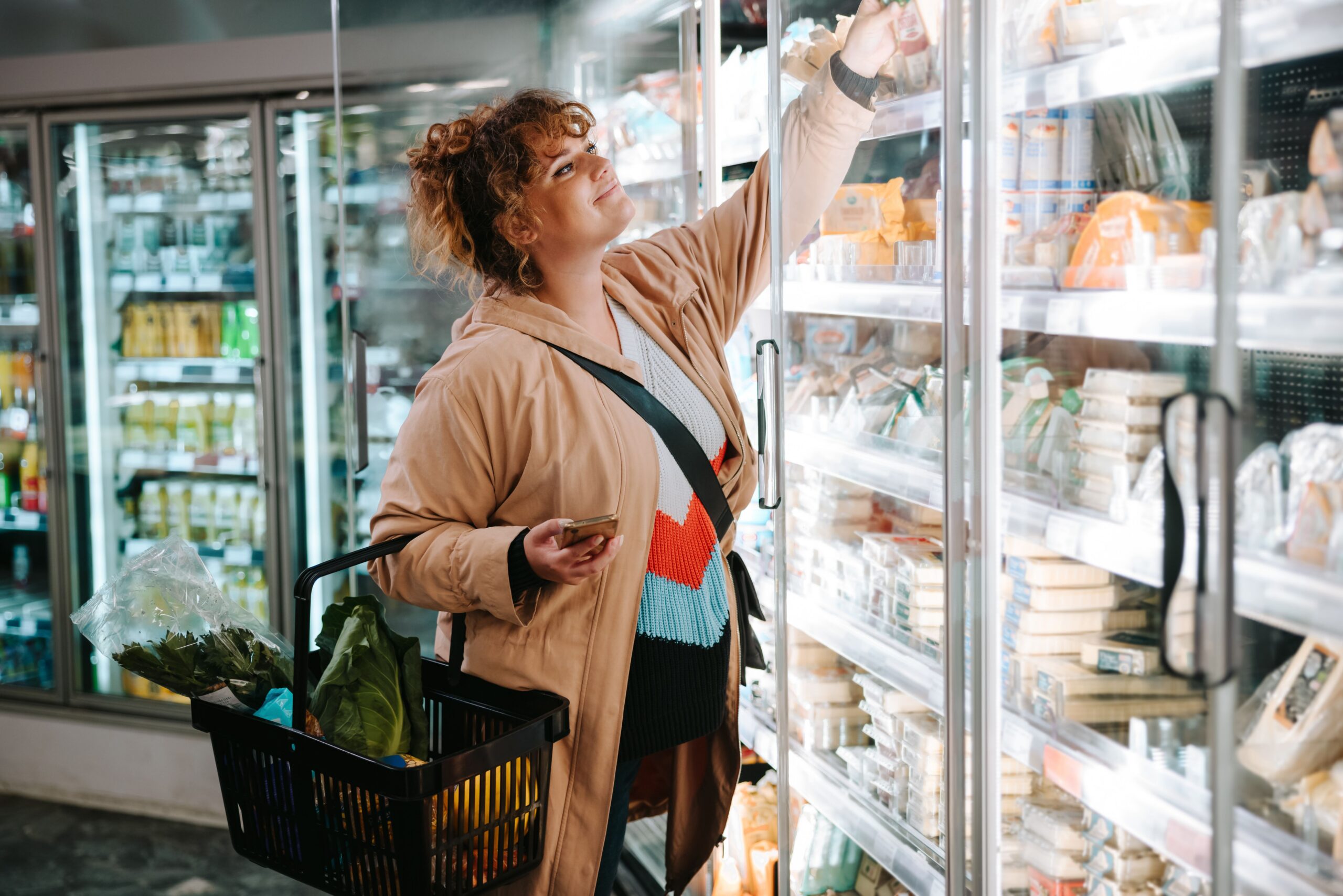 shopper selecting items from refrigerated aisle scaled